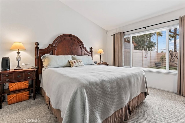 carpeted bedroom featuring baseboards and vaulted ceiling