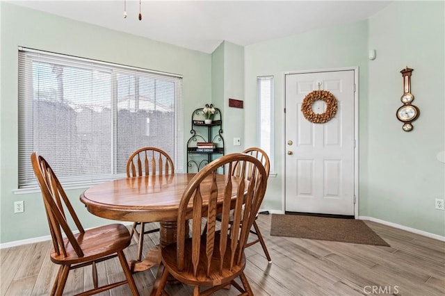 dining room featuring baseboards and light wood finished floors