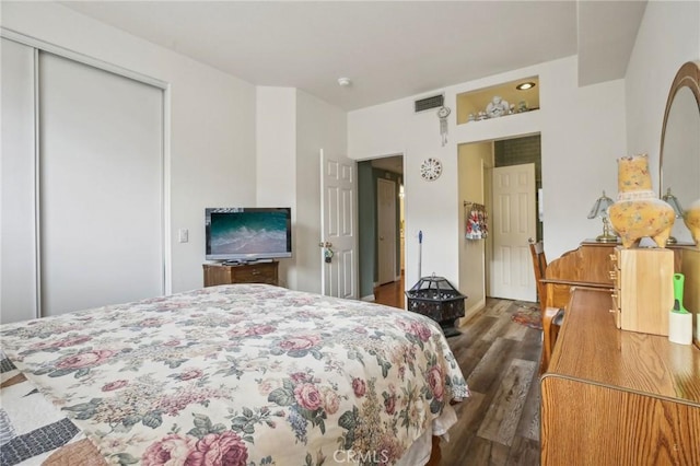 bedroom featuring visible vents, a closet, and dark wood-style floors