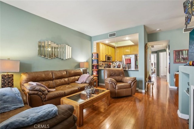 living area featuring hardwood / wood-style floors, baseboards, and visible vents