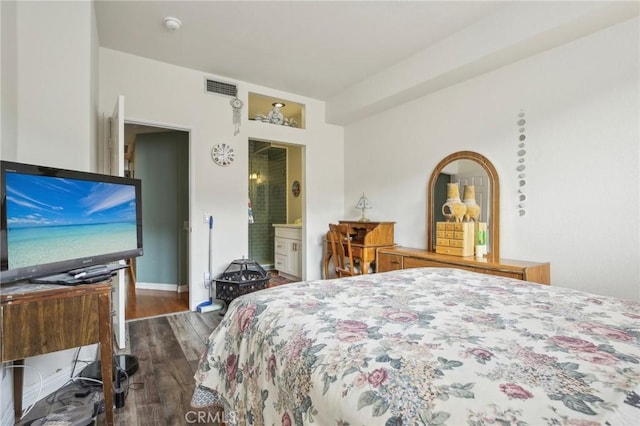 bedroom with visible vents, wood finished floors, and ensuite bathroom