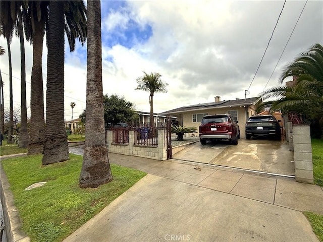 view of front of home with concrete driveway and fence