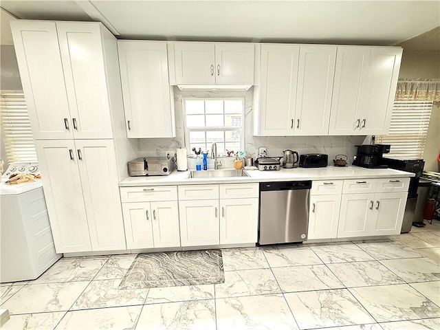 kitchen with marble finish floor, a sink, light countertops, washer / dryer, and dishwasher