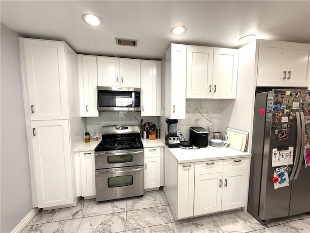 kitchen with visible vents, marble finish floor, white cabinetry, stainless steel appliances, and light countertops