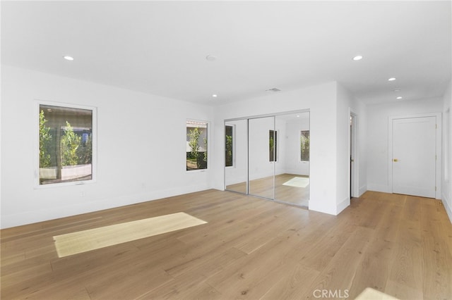 unfurnished bedroom with light wood-style flooring, recessed lighting, a closet, and baseboards