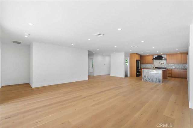 unfurnished living room with light wood finished floors, visible vents, and recessed lighting