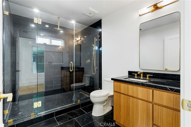 bathroom featuring marble finish floor, toilet, a shower stall, and vanity