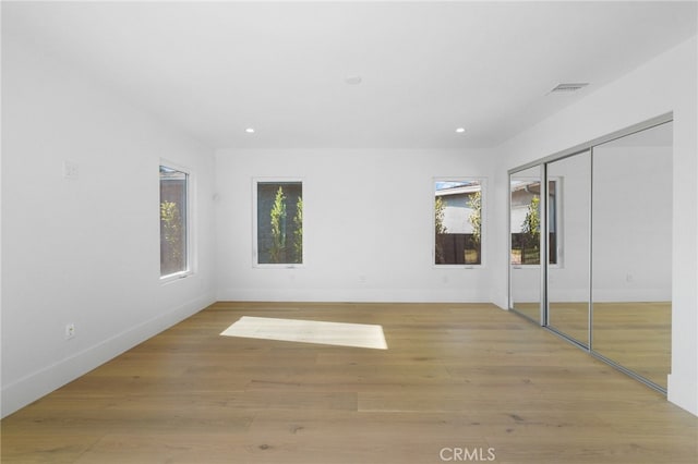 unfurnished bedroom with recessed lighting, visible vents, baseboards, and wood finished floors