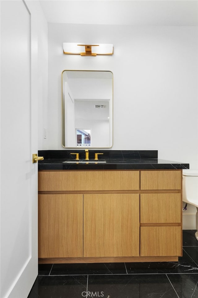 bathroom featuring toilet and vanity