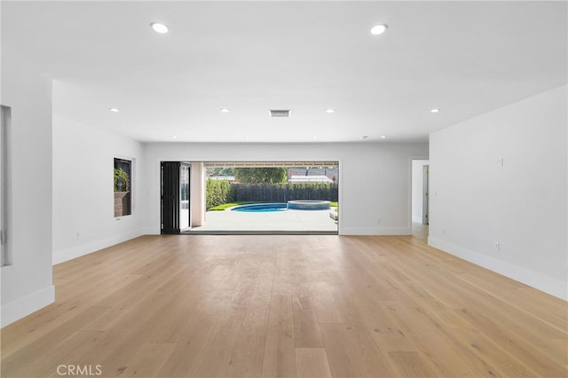 unfurnished living room featuring baseboards, recessed lighting, visible vents, and light wood-type flooring