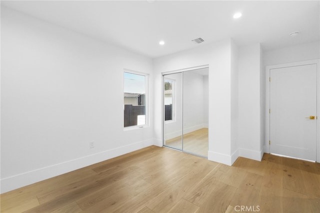 unfurnished bedroom with visible vents, recessed lighting, a closet, light wood finished floors, and baseboards