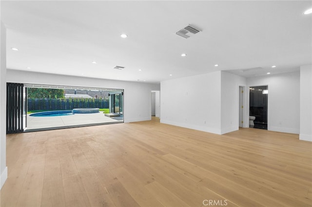 unfurnished living room with recessed lighting, visible vents, baseboards, and light wood-style floors