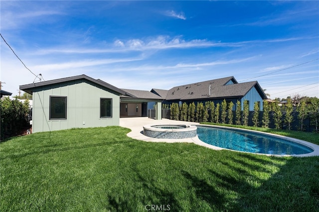 rear view of house featuring a patio, a pool with connected hot tub, a yard, and fence