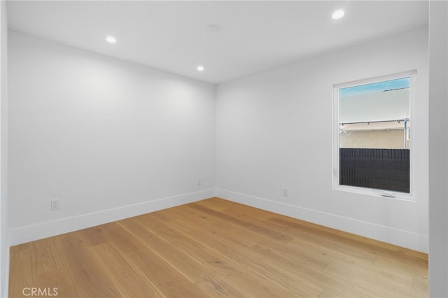 empty room featuring recessed lighting, baseboards, and light wood-style flooring