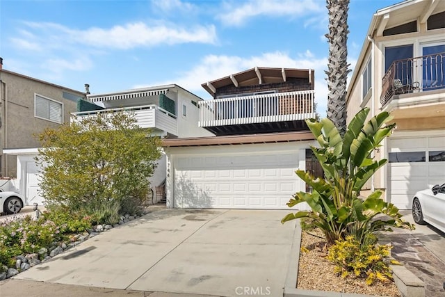 view of front of property featuring a balcony, driveway, and a garage