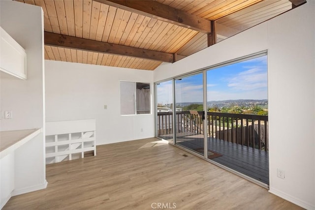 empty room with wood ceiling, vaulted ceiling with beams, and wood finished floors