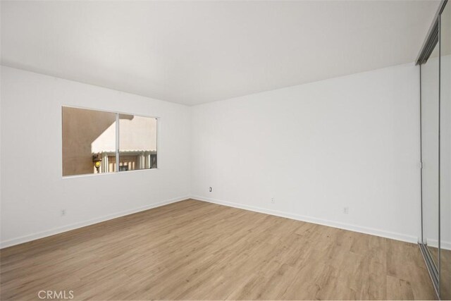 empty room with baseboards and light wood-style floors