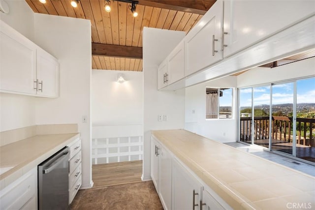 kitchen featuring vaulted ceiling with beams, dishwasher, wood ceiling, light countertops, and white cabinets