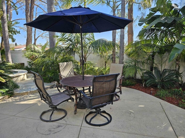 view of patio featuring outdoor dining area and fence