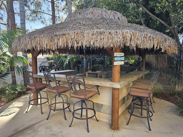 view of patio / terrace with exterior bar and fence