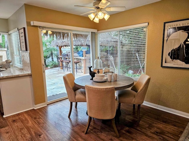 dining room featuring wood finished floors, baseboards, a textured wall, and ceiling fan