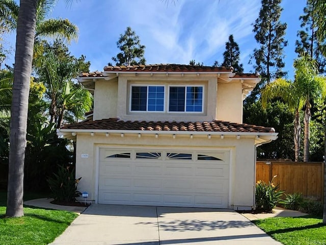 mediterranean / spanish house with fence, driveway, an attached garage, stucco siding, and a tiled roof