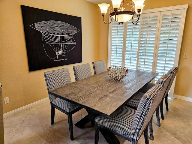 tiled dining area with baseboards and a chandelier