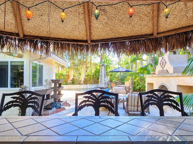 view of patio featuring outdoor dining space, a gazebo, and exterior fireplace