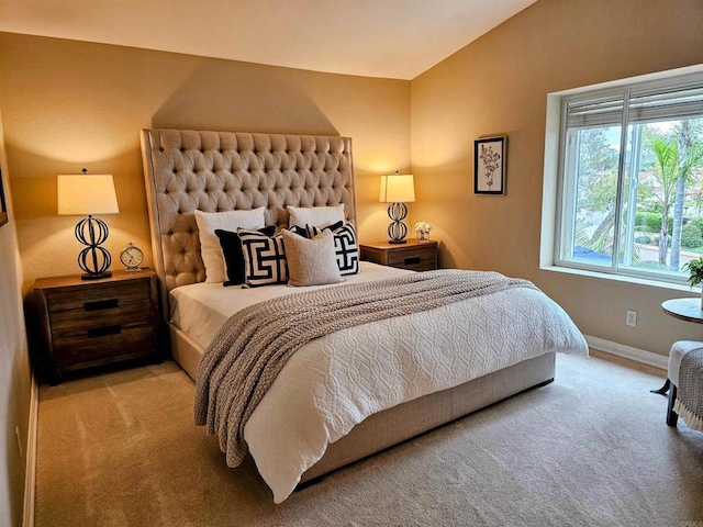 carpeted bedroom featuring vaulted ceiling and baseboards