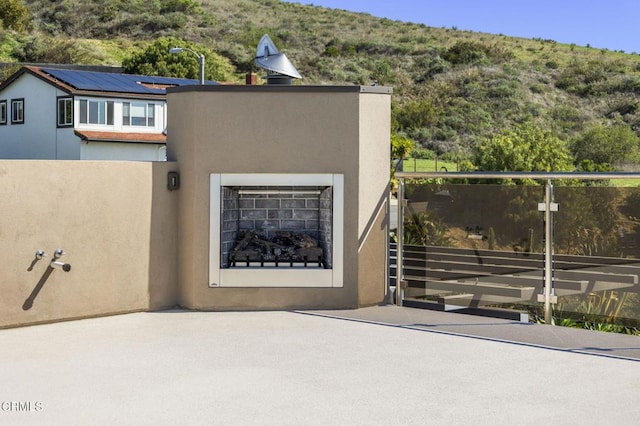 view of front of house featuring stucco siding and an outdoor fireplace