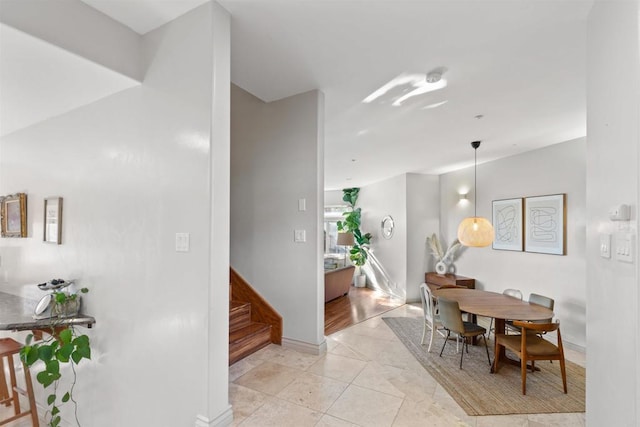 dining room with baseboards and stairs