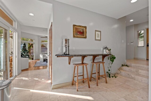 bar with light tile patterned flooring, recessed lighting, and baseboards