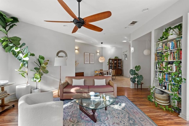 living room featuring visible vents, a ceiling fan, and wood finished floors