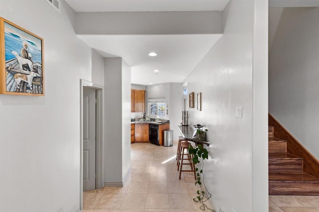 corridor with light tile patterned floors, stairway, recessed lighting, and visible vents