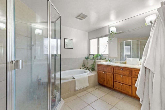 bathroom featuring visible vents, a shower stall, a garden tub, tile patterned floors, and vanity