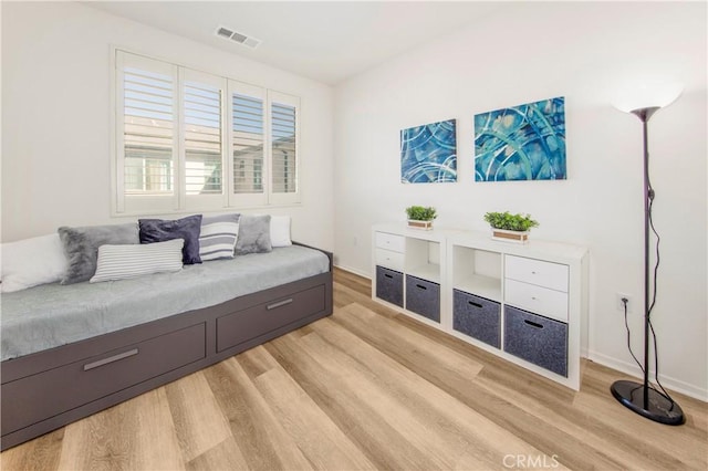 living area featuring visible vents, light wood-style flooring, and baseboards