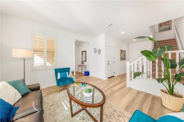 living room featuring stairs, recessed lighting, wood finished floors, and visible vents