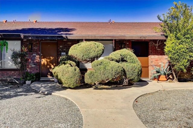 ranch-style house with brick siding and a shingled roof