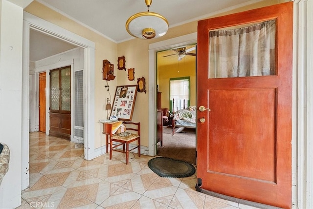 hallway featuring light tile patterned floors, baseboards, and ornamental molding