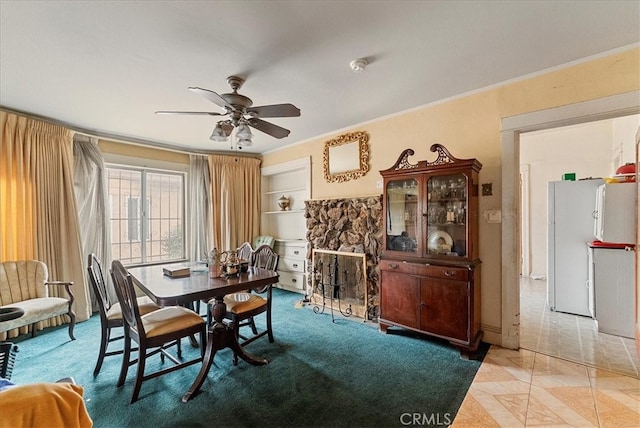 dining area featuring built in shelves, ceiling fan, and ornamental molding