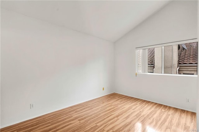 unfurnished room featuring lofted ceiling and wood finished floors