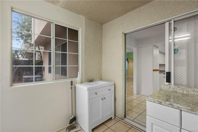 bathroom featuring vanity, tile patterned floors, and a textured ceiling