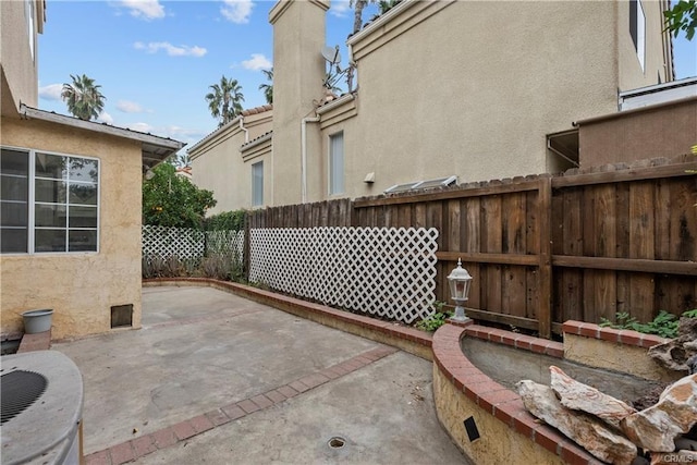 view of patio featuring central AC unit and fence