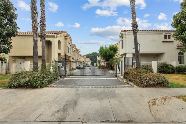 view of street with a gated entry, curbs, and a gate