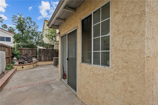 view of patio with central AC unit and fence