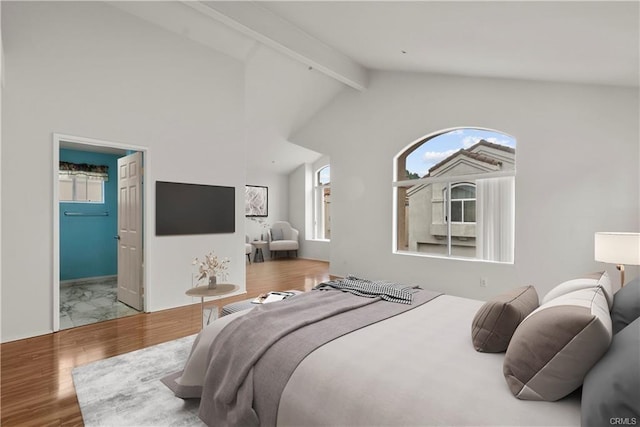 bedroom featuring multiple windows, wood finished floors, and vaulted ceiling with beams