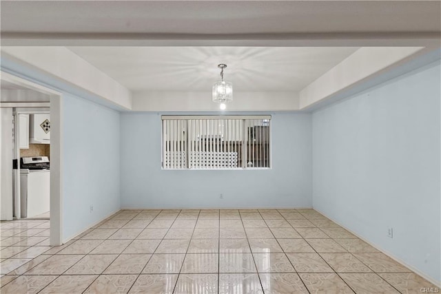 empty room featuring light tile patterned floors, a notable chandelier, and washer / dryer