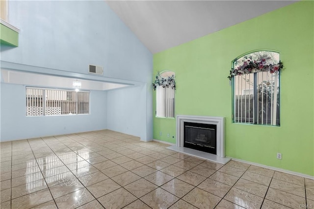 unfurnished living room with tile patterned floors, visible vents, a fireplace, and high vaulted ceiling