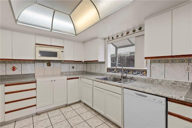 kitchen featuring a sink, white appliances, white cabinets, light tile patterned floors, and decorative backsplash