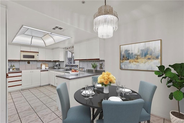 dining space with an inviting chandelier, light tile patterned flooring, and visible vents